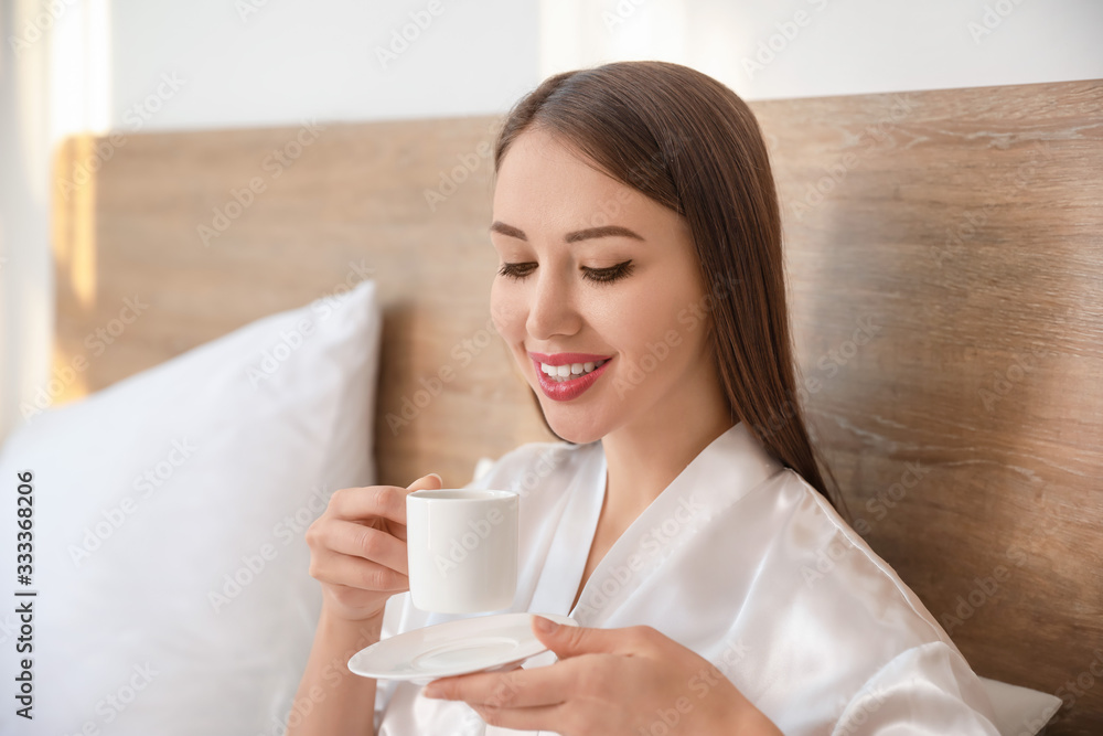 Morning of beautiful young woman having breakfast in bed