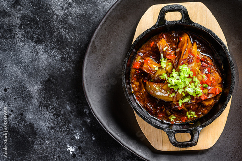 baked eggplant in tomato sauce. Black background. Top view. Copy space