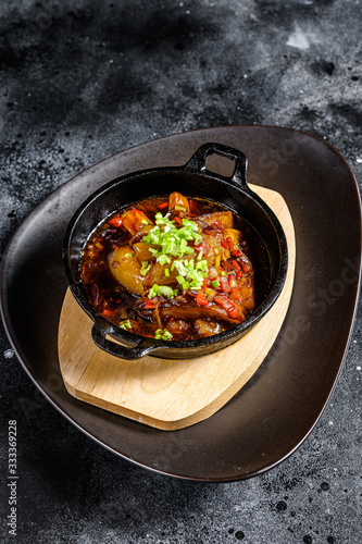 baked eggplant in tomato sauce. Black background. Top view
