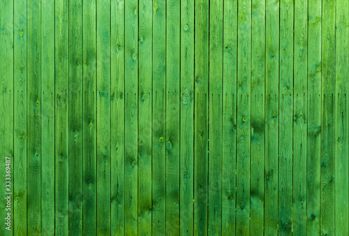 Old fence painted in light green  wooden background. Light green wooden planks background texture.