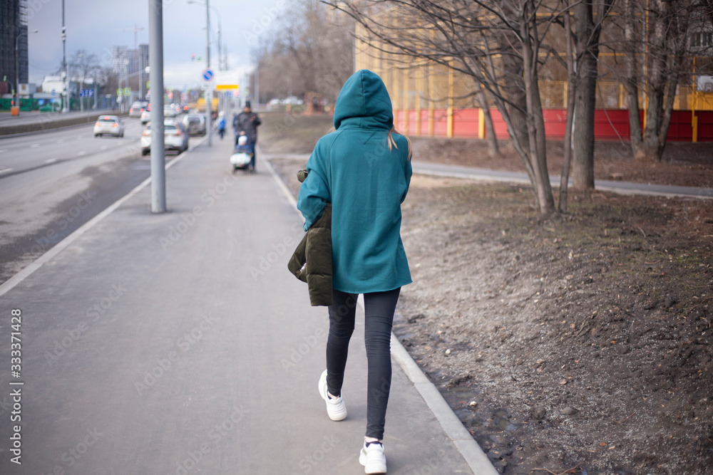 A girl is walking down the street.