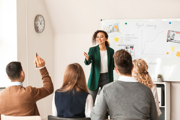 Female interior designer teaching young people in office