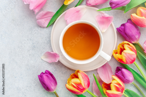 A cup of tea with tulips on white background