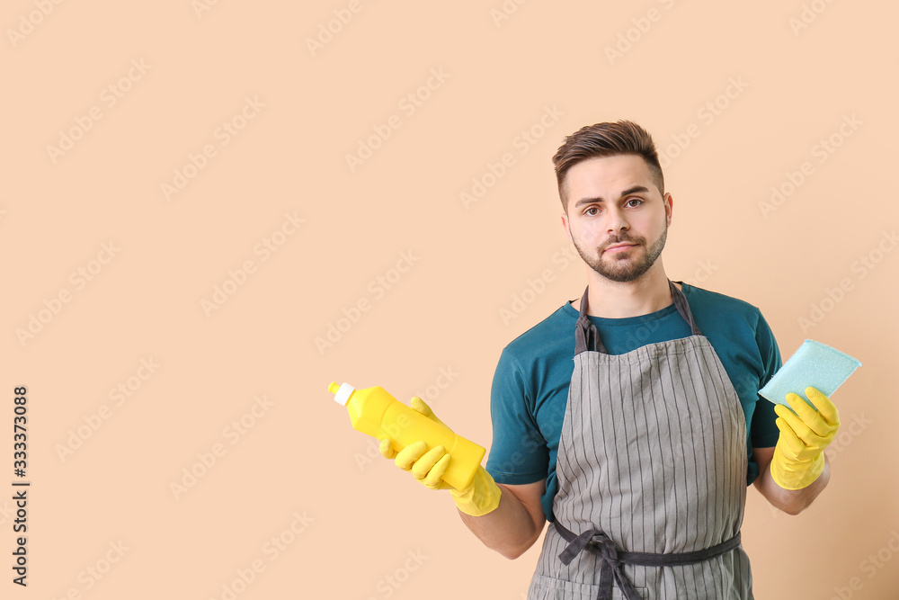 Young man with detergent and rag on color background Young man with detergent and rag on color background
