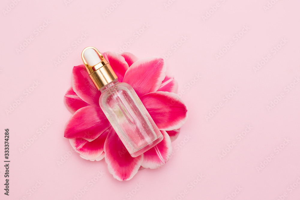 Medical essential oil on spring flower on pink background with a copy space Medical essential oil on spring flower on pink background with a copy space