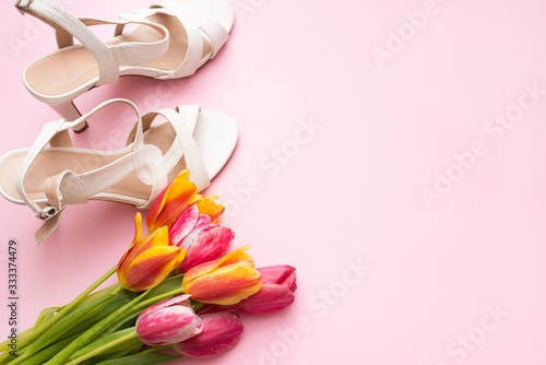 Fototapeta Naklejka Na Ścianę i Meble -  Women flat lay with sandals and bouquet of tulips on pink background with a copy space