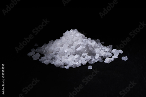 Heap of coarse salt on a black background.