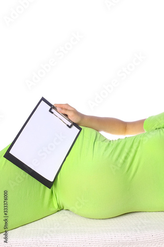 Happy pregnant girl expecting a baby with a tablet lies on a white background. Medicine for women message on tablet.