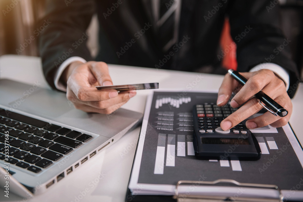 Business people use calculators to calculate company performance numerals, monthly graphs for meetings and pay for products via the company's credit card. Business people use calculators to calculate company performance numerals, monthly graphs for meetings and pay for products via the company's credit card.