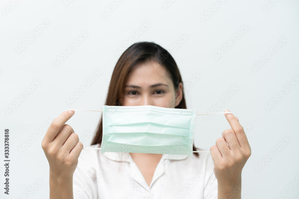 White shirt, woman looked at a medical mask to prevent the flu and the Covid-19 coronary virus, focus on the mask White shirt, woman looked at a medical mask to prevent the flu and the Covid-19 coronary virus, focus on the mask