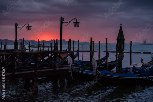 Little pier with gondolas at sunrise. Charming romantic Venice. Travel and rest © WellStock