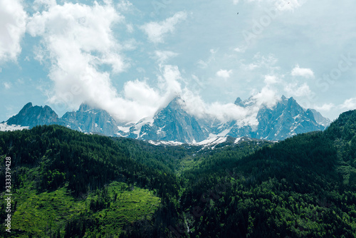 Outdoor landscape in Chamonix. Mountain meadows and snow-capped mountains in clouds. Alps  France