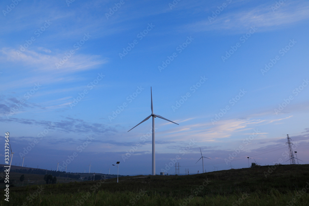 Obraz premium The windmill in the sunset, on the hillside