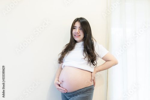 Pregnant woman feeling happy at home while taking care of her child. Maternity prenatal care and woman pregnancy concept. Free Download Pregnant woman feeling happy at home while taking care of her child. Maternity prenatal care and woman pregnancy concept. - GFXLoad