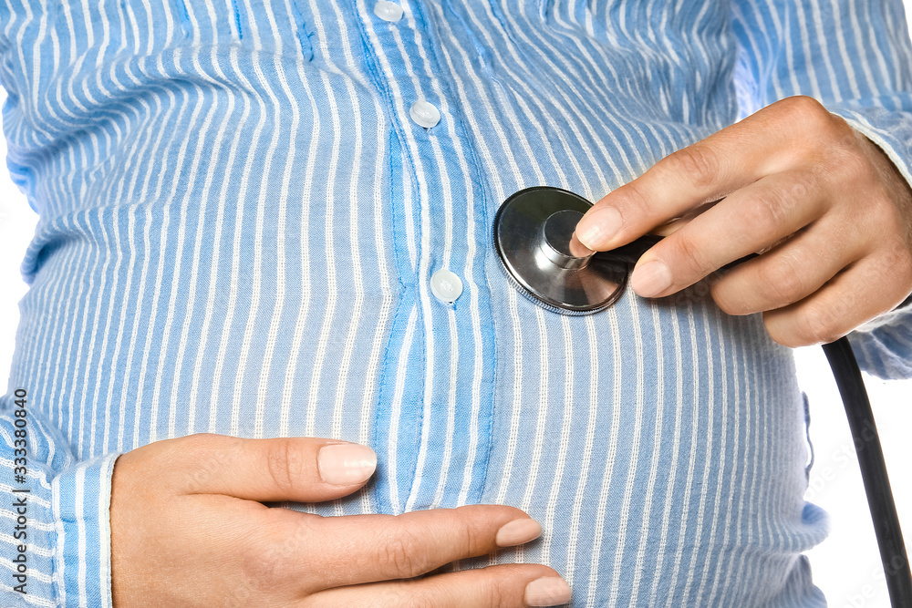 Fototapeta premium Happy pregnant girl with a statoscope in hands on a white background