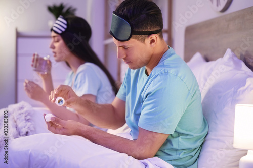 Young couple taking pills f...