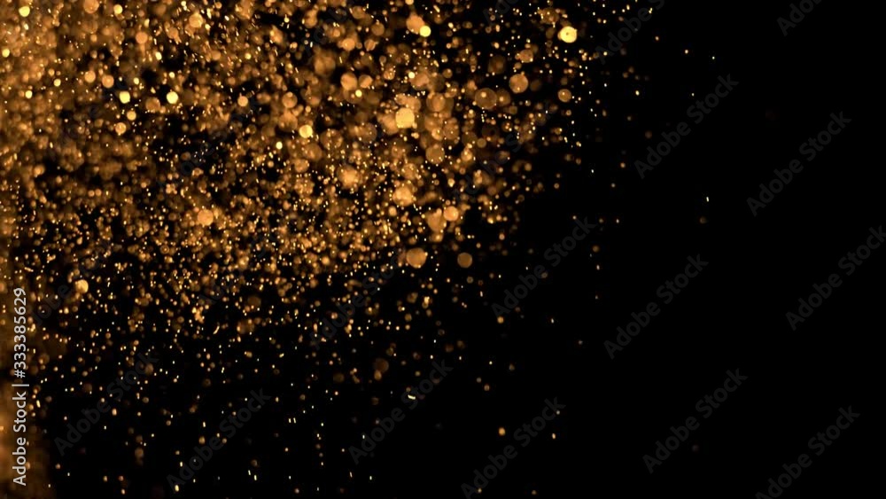 Super slow motion of glittering golden particles on black background. Shallow depth of focus. Filmed on high speed cinema camera, 1000 fps. Super slow motion of glittering golden particles on black background. Shallow depth of focus. Filmed on high speed cinema camera, 1000 fps.