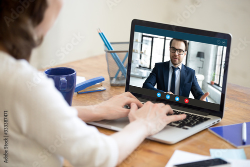 Laptop screen view confident male boss leader holding videoconference business negotiations with female partner worker employee due to coronavirus covid19 world outbreak quarantine  remote online job.