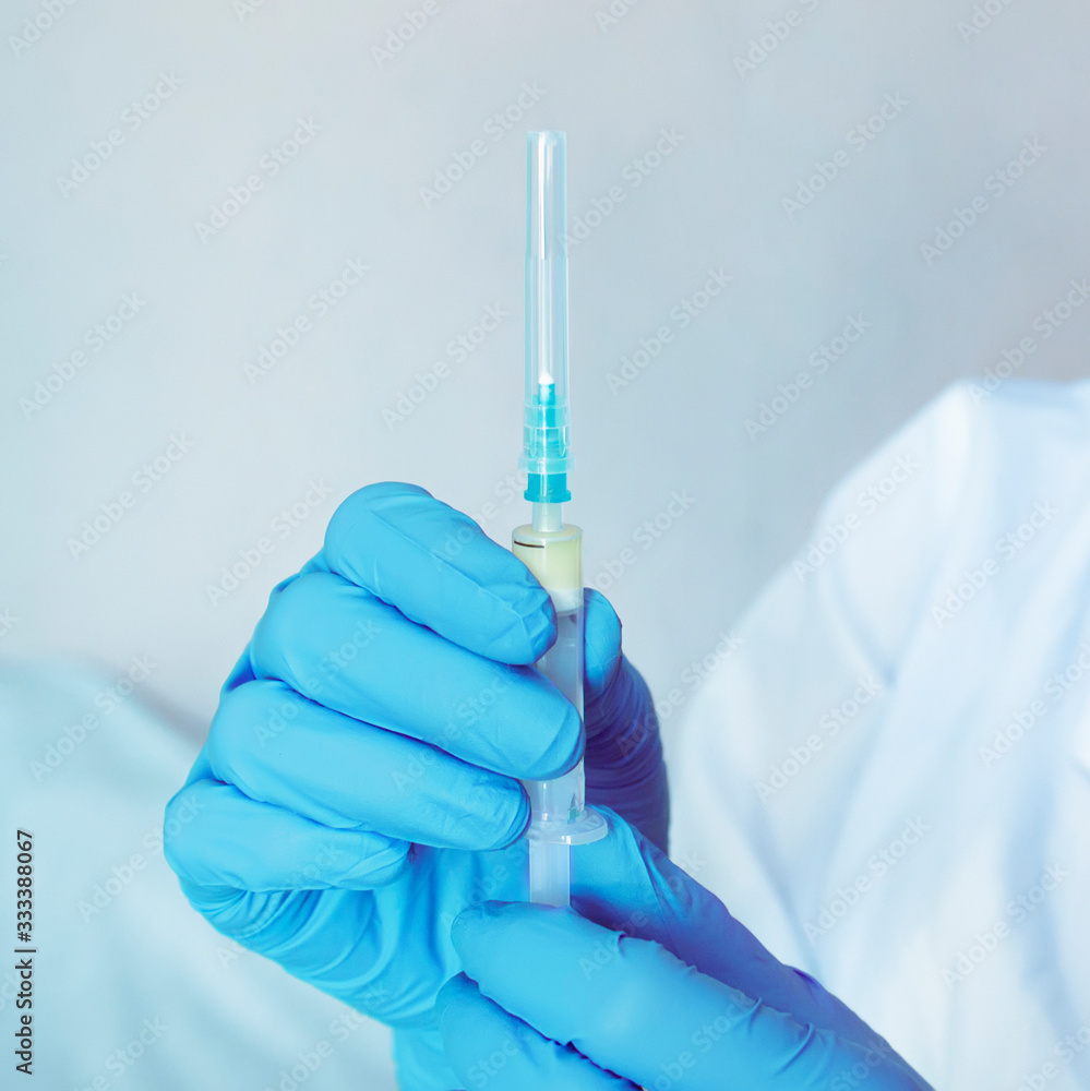 A nurse in rubber gloves holds a syringe. A single-use syringe containing the vaccine. Sterility. A nurse in rubber gloves holds a syringe. A single-use syringe containing the vaccine. Sterility.