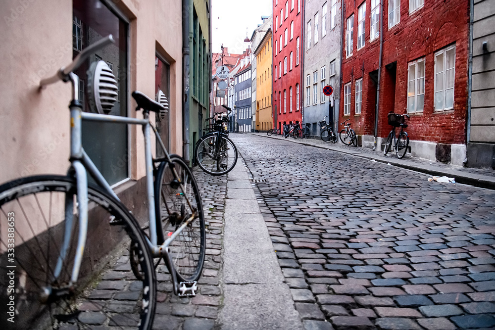 Bikes standing near colored houses on a narrow street in the historic center of Copenhagen, Denmark. February 2020