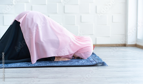 muslim woman pray on hijab praying on mat indoors photo