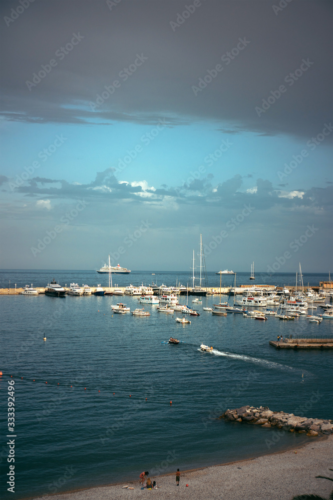 Panoramic view of white luxury yachts and sailing boats moored in harbor of Santa Margherita Ligure, Italian Riviera. Beautiful mediterranean landscape with cloudy blue sky.
