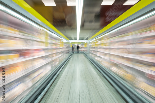 Gang mit Kühlschränken in einem Supermarkt mit Kunden