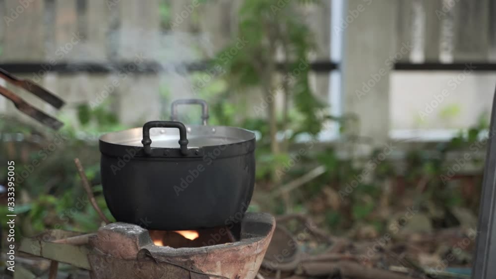 Thai traditional cooking by putting pot over fire hot charcoal clay stove Thai traditional cooking by putting pot over fire hot charcoal clay stove