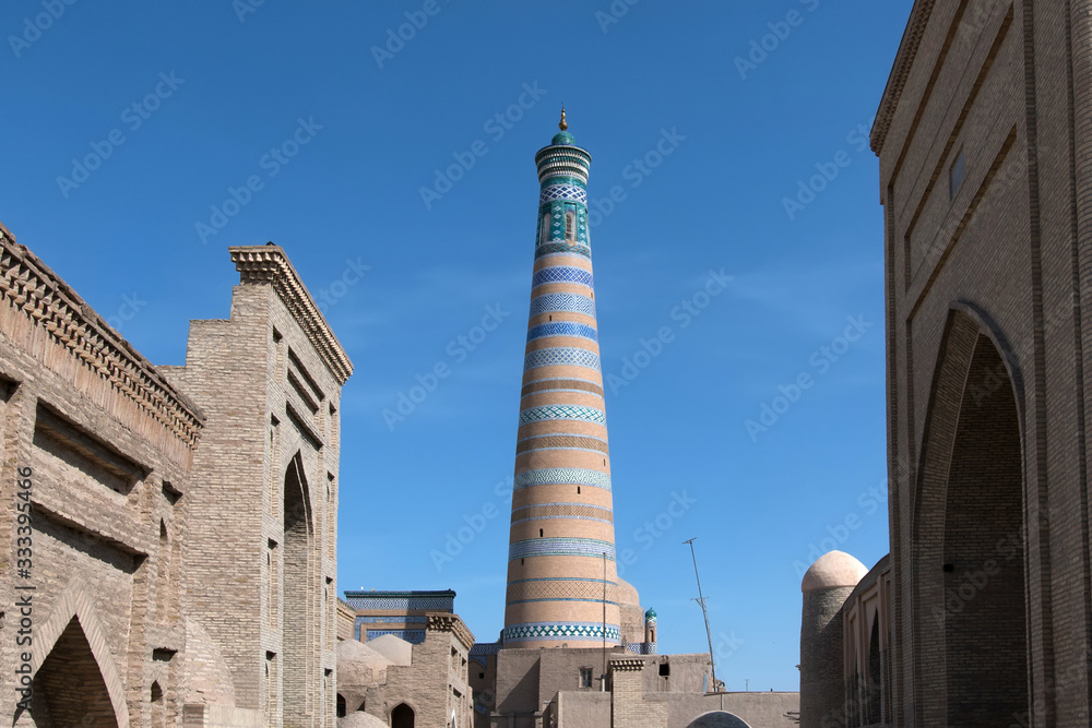 View at Itchan Kala (old or inner town). Pahlavon Mahmud mausoleum (left), Islam Khoja Minaret (centre) and Shergazi-Khan Madrasah (right). Khiva, Uzbekistan, Central Asia.