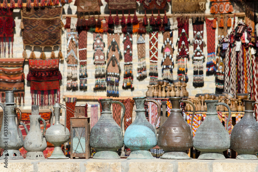Carpets and metal jugs on the street. Popular traditional uzbek souvenirs. Bukhara, Uzbekistan.
