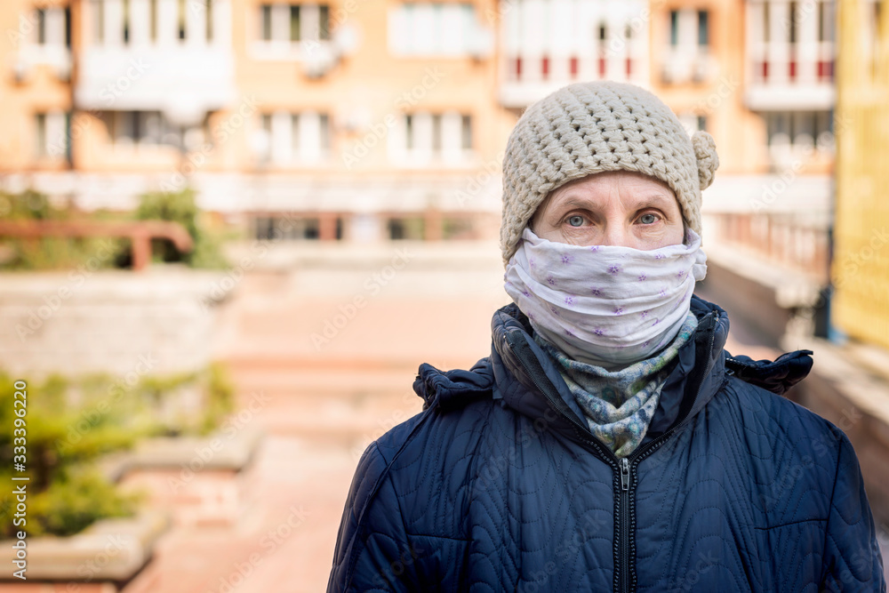 A poor elderly woman wears a homemade mask to protect herself from viruses such as coronavirus, also known as covid-19, or SARS and MERS. She's in an urban environment A poor elderly woman wears a homemade mask to protect herself from viruses such as coronavirus, also known as covid-19, or SARS and MERS. She's in an urban environment