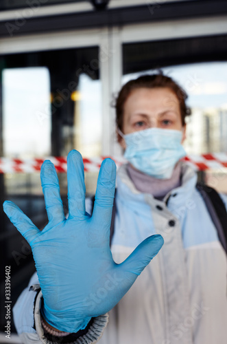 Woman wearing hygienic mask and medical latex blue gloves to prevent the Coronavirus.People in masks The outbreak of Novel Corona virus (2019-nCoV) in Europe.Concept of coronavirus quarantine