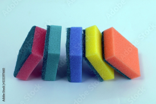  multi-colored sponges for dishes lie on a blue background