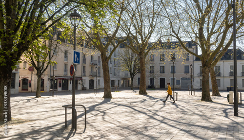 Masked girl walking through empty plaza in Tours, France