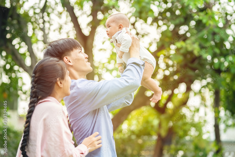 Happy family concept.Happy young asian couple parent having fun with little son,Dad holding up male infant with arms mom standing beside with love. Happy family concept.Happy young asian couple parent having fun with little son,Dad holding up male infant with arms mom standing beside with love.
