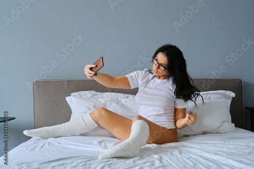 Photography Beautiful brunette in glasses posing for selfie on smartphone