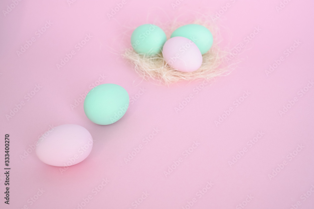 Eggs in nest of pink and mint color, several next to pink background. Easter concept