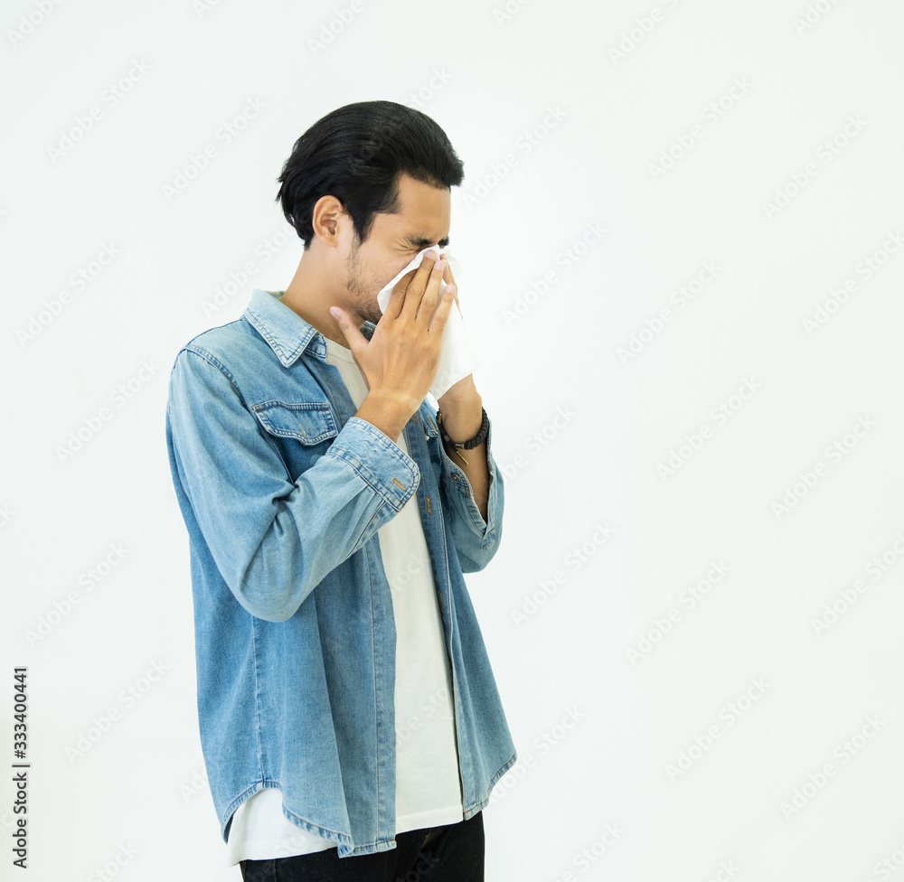 Young Asian handsome man in casual jeans dress having flu season and sneeze using paper tissues prevent spreading virus and bacteria isolated on white background, Health and illness concepts. Young Asian handsome man in casual jeans dress having flu season and sneeze using paper tissues prevent spreading virus and bacteria isolated on white background, Health and illness concepts.