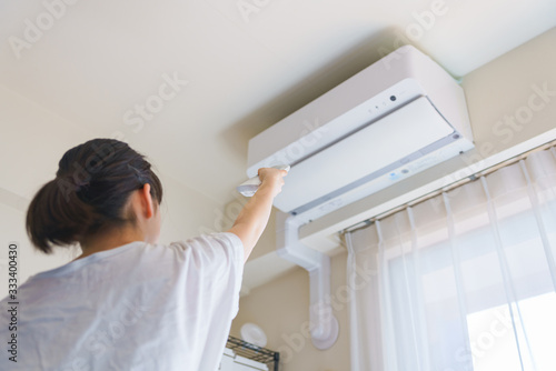 エアコン　温度調節　換気　冷房　夏　リモコン　リビング　人物　女性　日本人　ウィルス対策　空気清浄機