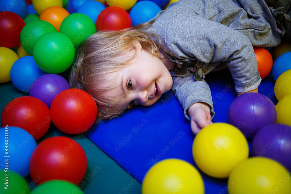 little girl 2 years old plays in a children's area with attractions little girl 2 years old plays in a children's area with attractions