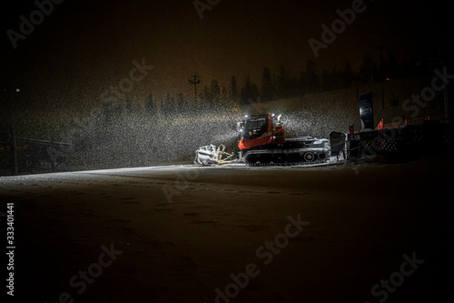 Snowcat preparing a slope at night