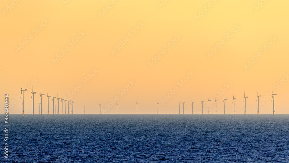 HORNSEA OFFSHORE WIND FARM, UK - 2016 JULY 15. Wind turbines of the Hornsea Offshore Wind Farm, offshore windfarm off the UK coast in the North Sea at sunset. HORNSEA OFFSHORE WIND FARM, UK - 2016 JULY 15. Wind turbines of the Hornsea Offshore Wind Farm, offshore windfarm off the UK coast in the North Sea at sunset.