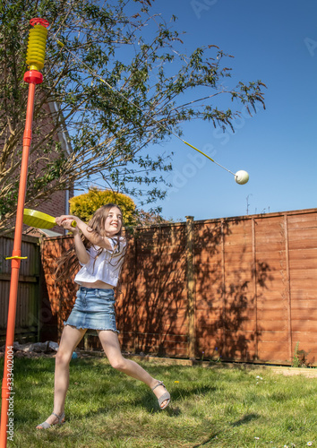 girl plays in the garden with bat an ball game
