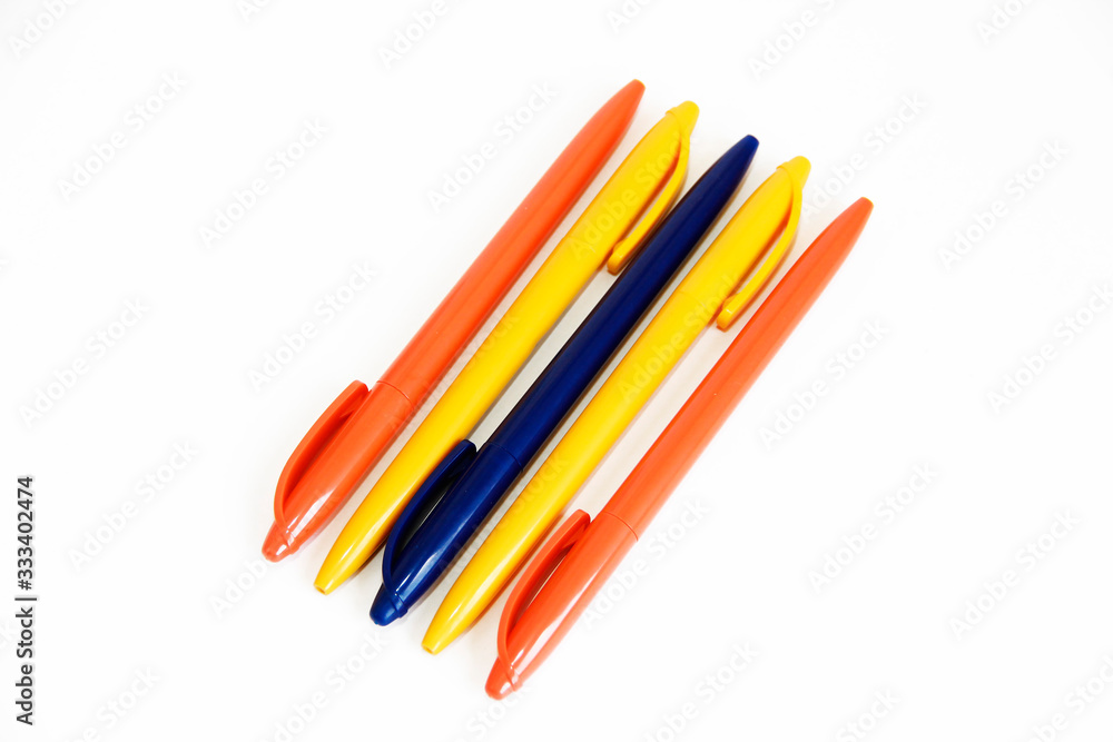 Fototapeta premium multicolored plastic stationery pens on a white background