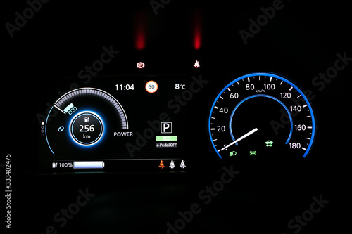 Starting electric car Dashboard. Track in to the button. Finger press the button to start the car engine. Car dashboard during start engine on the darkness. Electric car dashboard with backlight.
