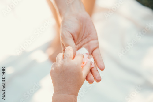 Hand of a child and mother. Hands on a light background. Children's hand.