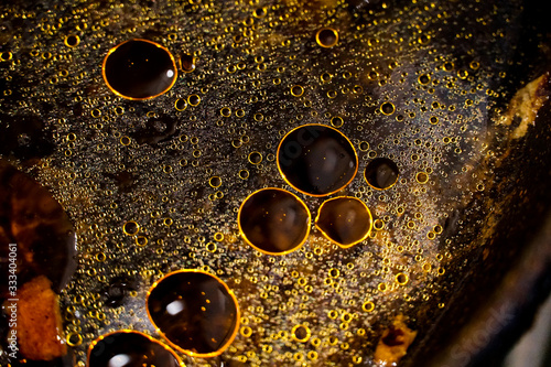 stains and bubbles of fat in water, circles and dots of orange, yellow, golden color, contrasting colorful background            