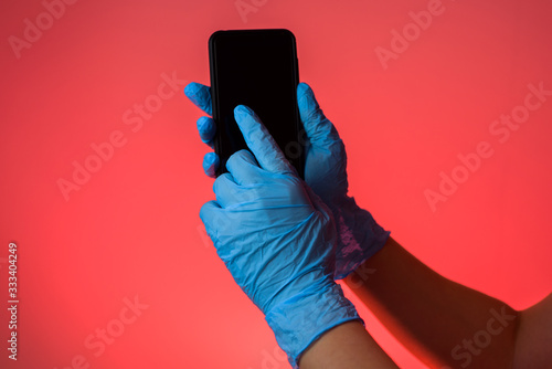 hands in the gloves touching scren on the smartphone