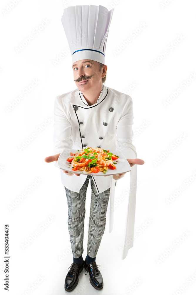 Chef cook in white uniform holds a plate with a shrimps pasta on a white background Chef cook in white uniform holds a plate with a shrimps pasta on a white background