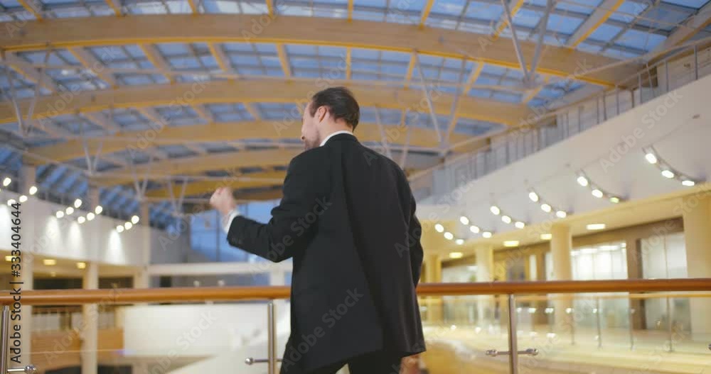 Happy businessman standing in the hall of the business center Happy businessman standing in the hall of the business center